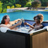 Couple relaxing in Relxtime aluminum frame hot tub outdoors with champagne